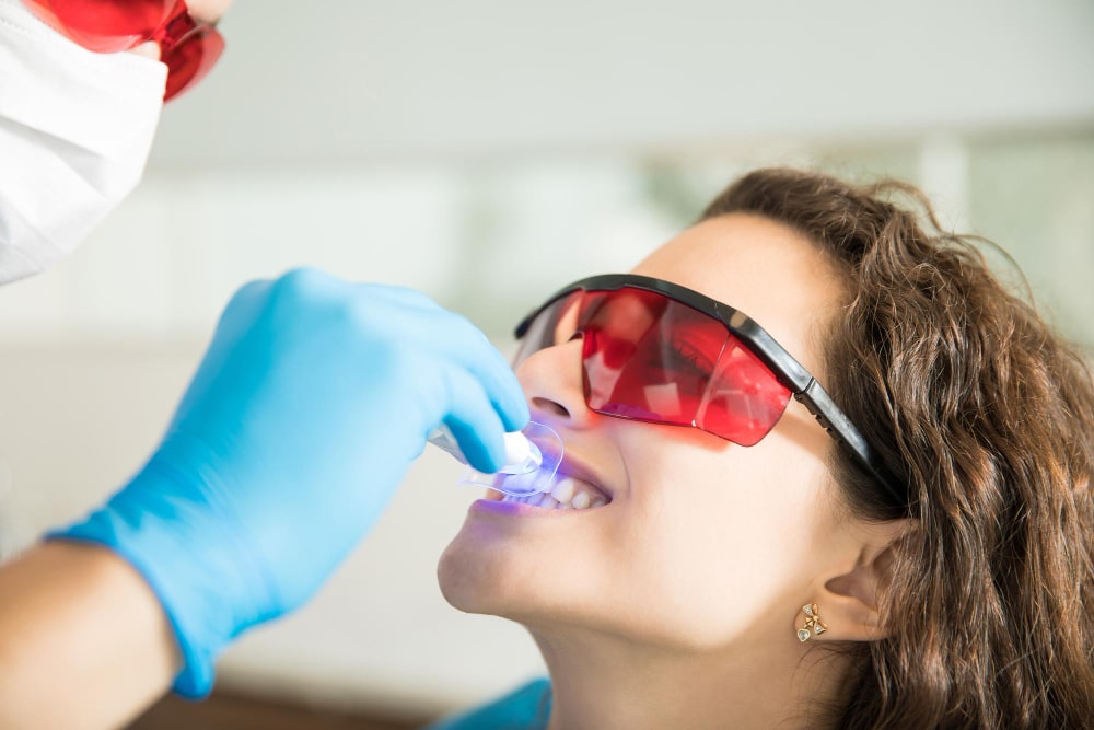 Woman undergoing teeth whitening procedure at Oak Hills Dentistry in Spring, TX