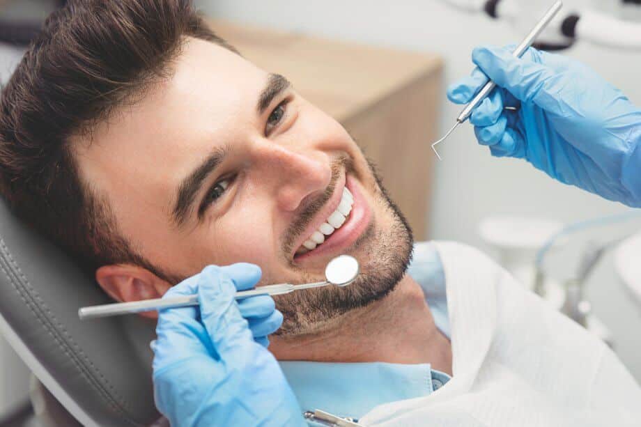 Man sitting in the dentist chair during full mouth reconstruction treatment in Spring, TX