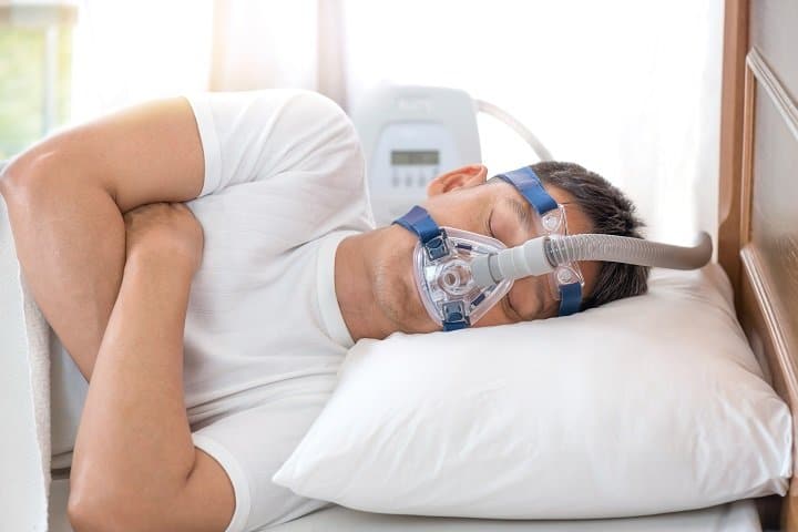 Man sleeping wearing a snoring treatment device in Spring, TX