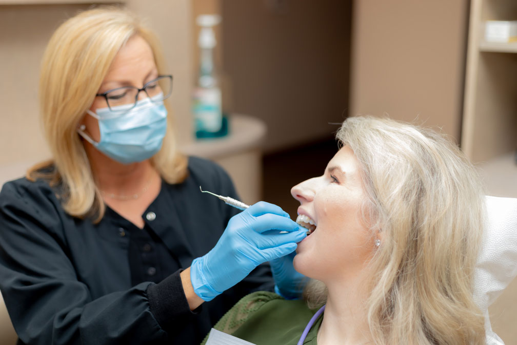 A woman and her dentist during a dental exam and cleaning in Spring, TX