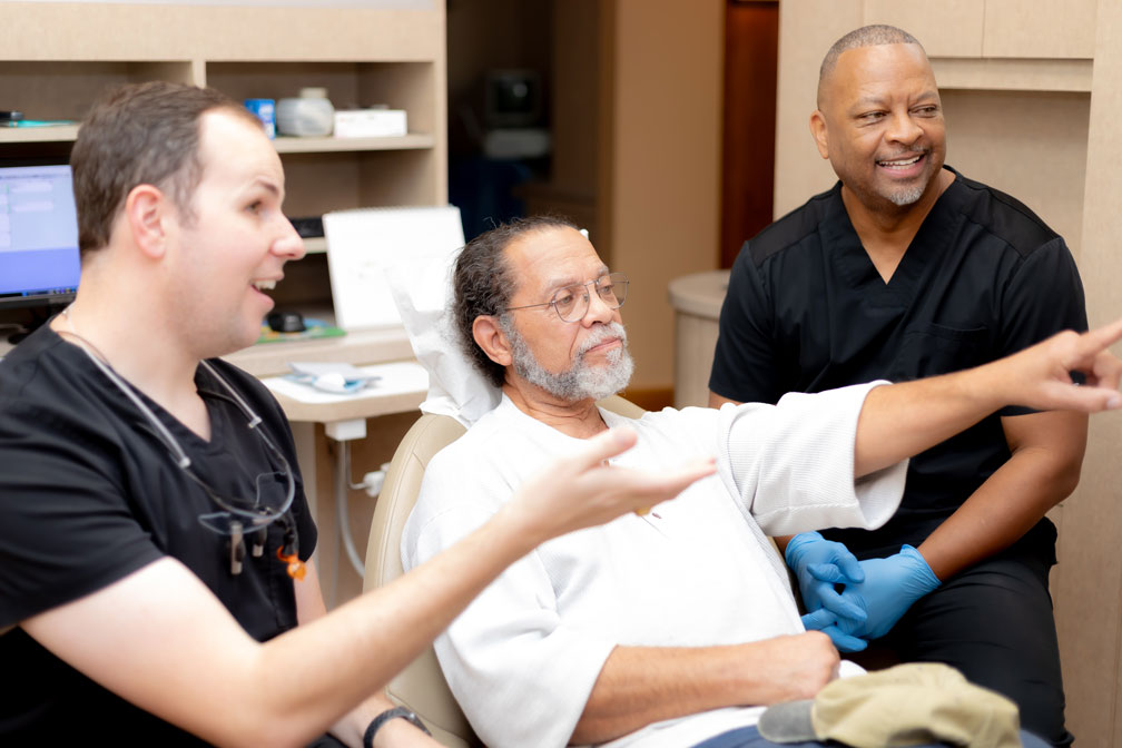 Dr. Smith and team discussing dental implants with a patient in Spring, TX